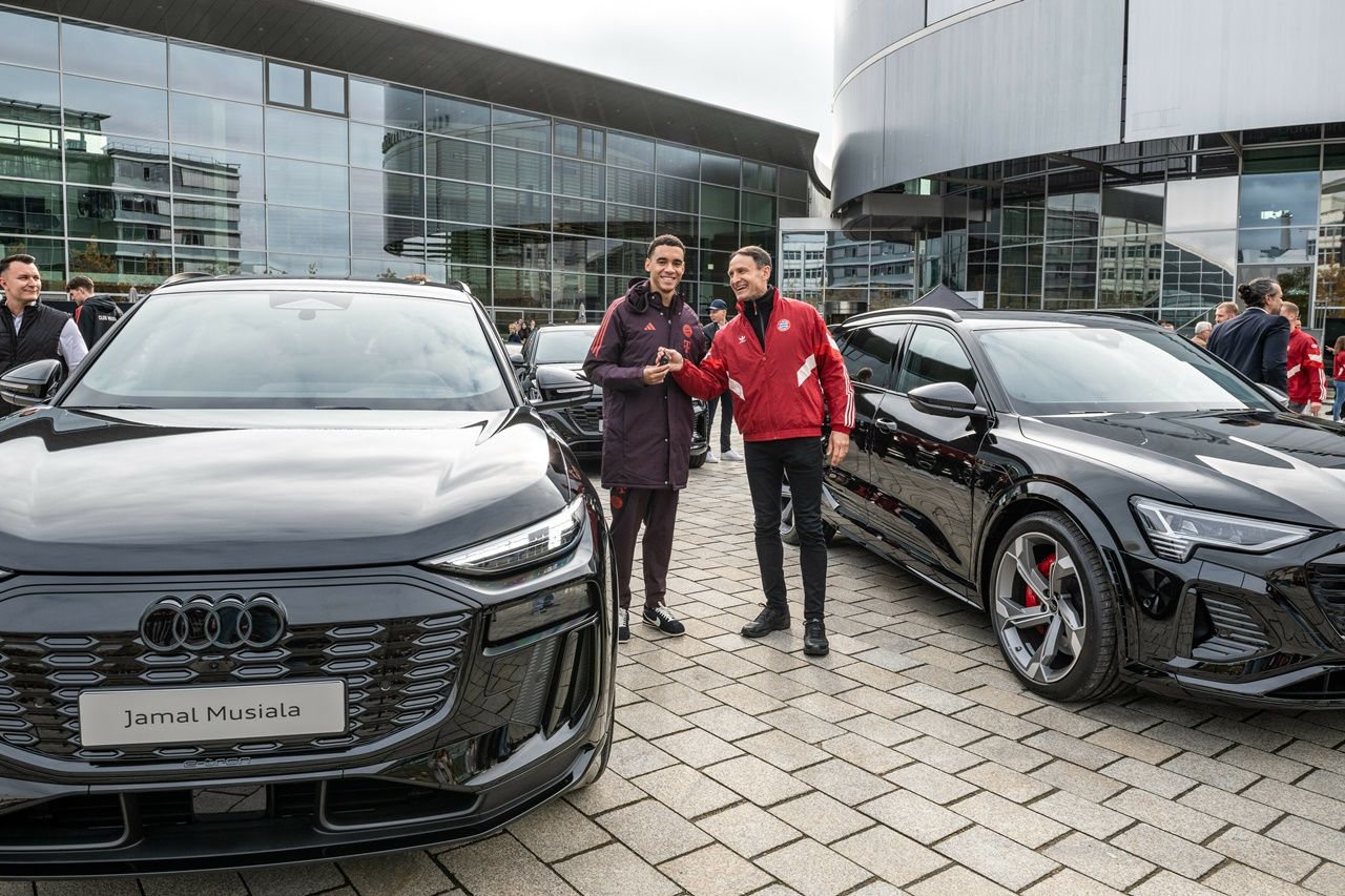 Przekazanie pojazdu w Audi Piazza w Ingolstadt: Gwiazda Bayernu Jamal Musiala otrzymuje kluczyki do samochodu z rąk pracownika Audi.